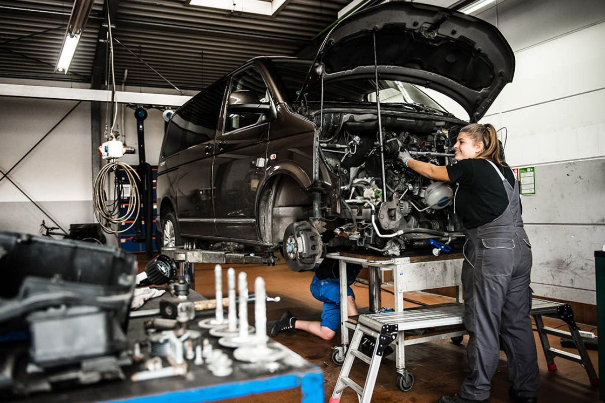 Mitarbeiterin arbeitet am Motor in der Werkstatt